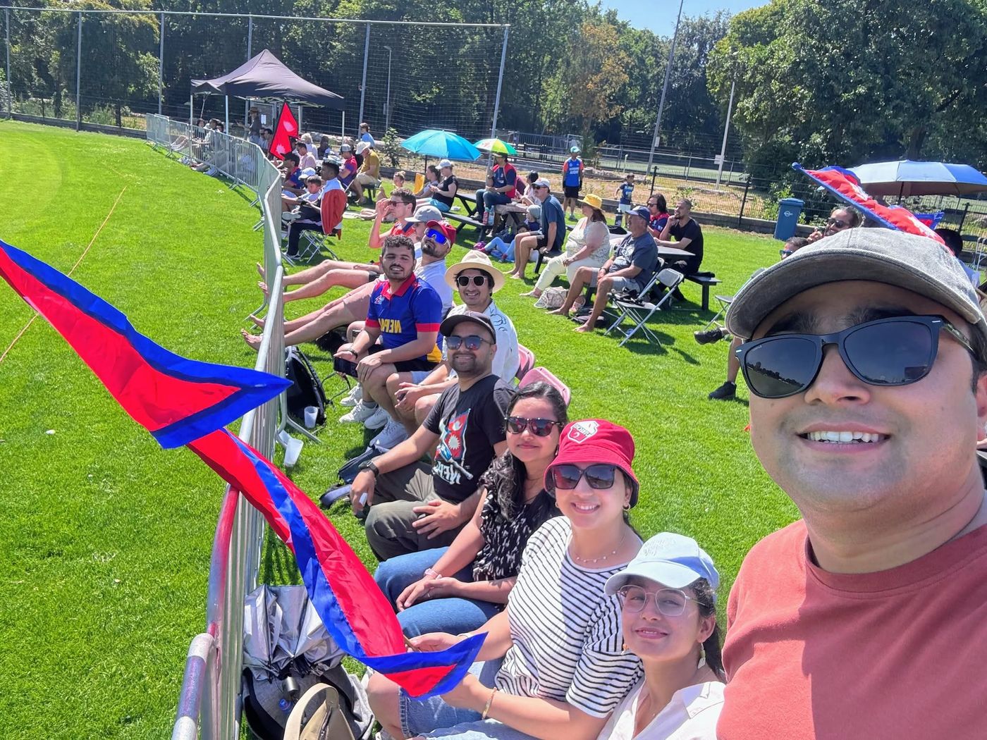 Cheering with Nepal flags at a cricket match