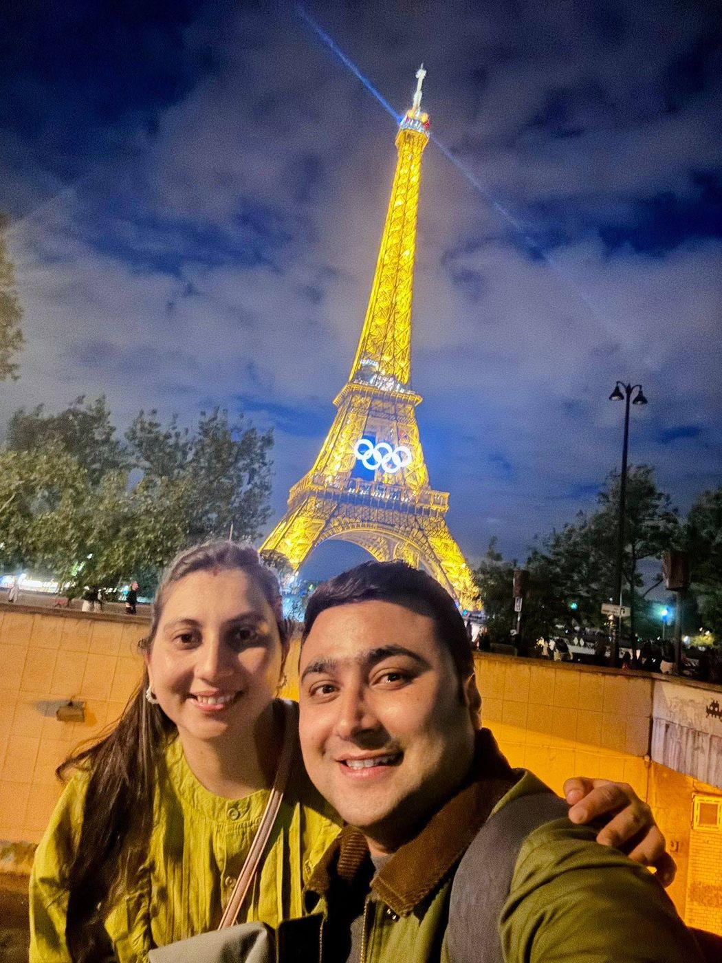 Selfie in front of the Eiffel Tower lit with Olympic rings